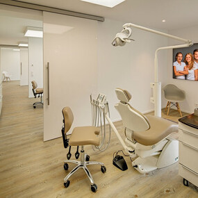 Modernes Behandlungszimmer in einer Zahnarztpraxis mit Zahnarztstuhl und freundlichem Ambiente.