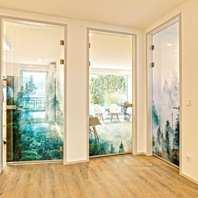 Moderne Praxis mit Glastüren und Waldmotiv, heller Wartebereich und Holzboden.